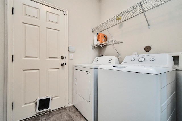 washroom with washing machine and dryer and dark tile patterned flooring