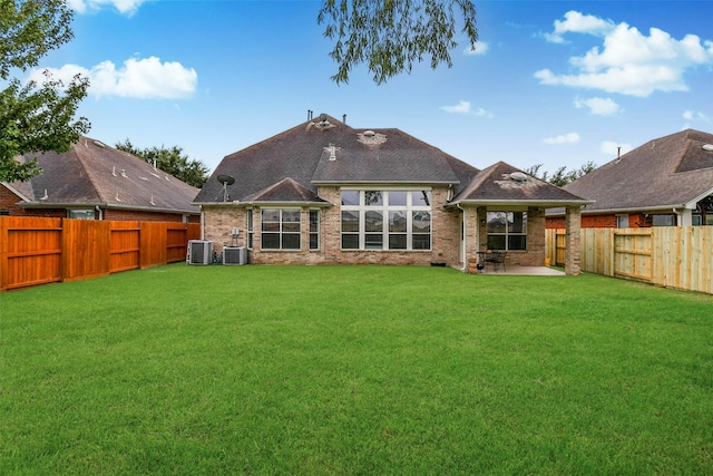 rear view of property featuring central AC, a yard, and a patio