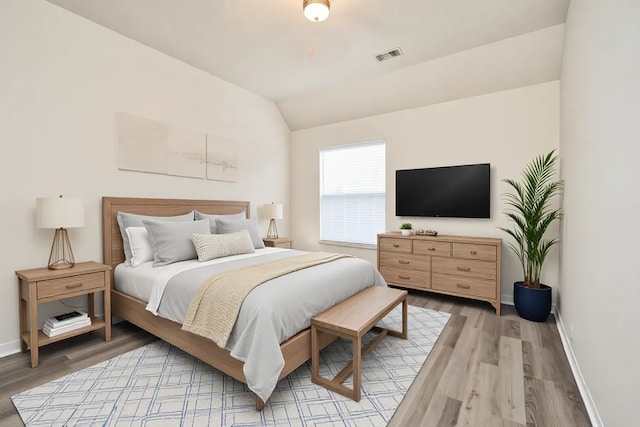 bedroom with hardwood / wood-style flooring and vaulted ceiling