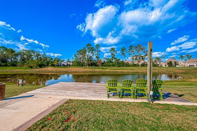 view of dock with a lawn and a water view