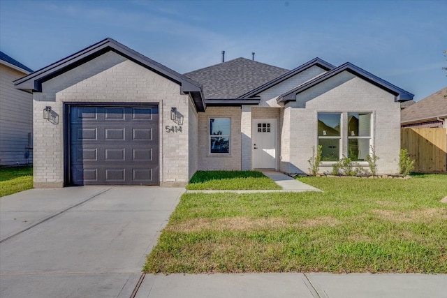 view of front of house featuring a garage and a front lawn