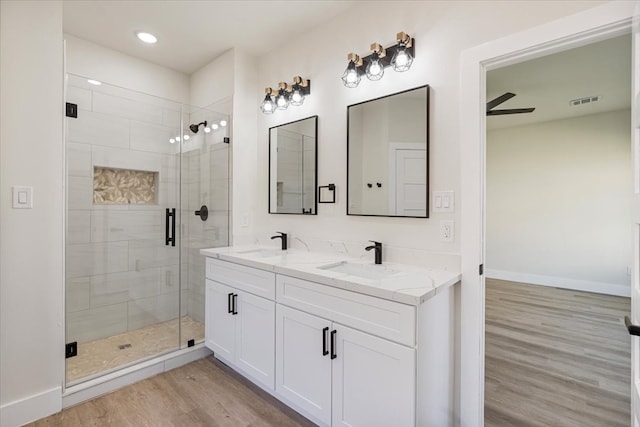 bathroom featuring ceiling fan, hardwood / wood-style floors, vanity, and a shower with door