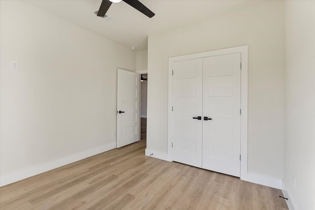 unfurnished bedroom with ceiling fan, light hardwood / wood-style floors, and a closet