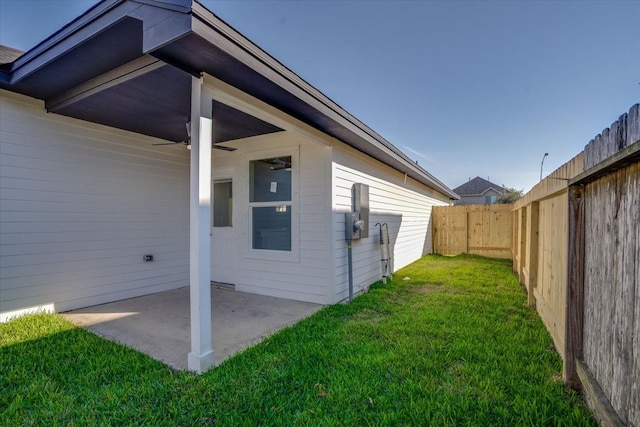 view of home's exterior with ceiling fan, a patio area, and a lawn