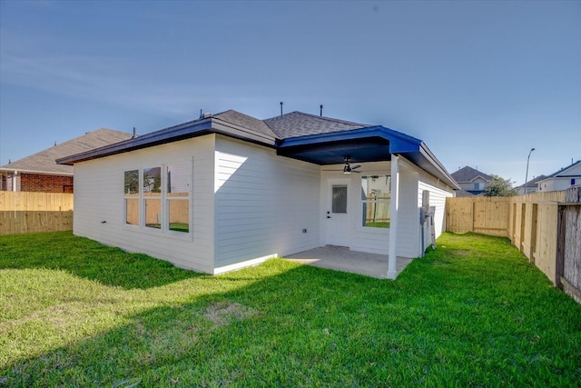 rear view of property featuring a lawn, ceiling fan, and a patio