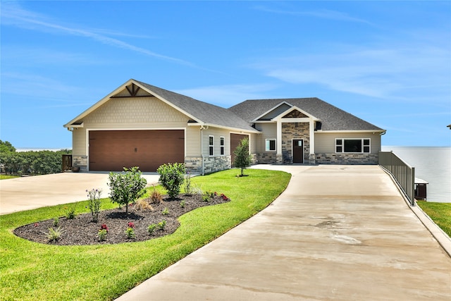 craftsman inspired home with a garage and a front lawn