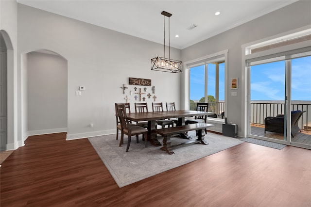 dining area featuring ornamental molding and dark wood-type flooring