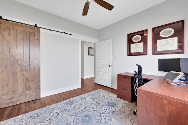 office space with a barn door, hardwood / wood-style flooring, and ceiling fan