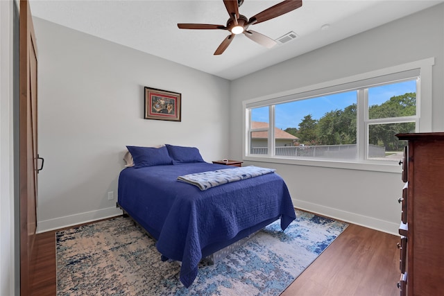 bedroom with ceiling fan and dark hardwood / wood-style flooring