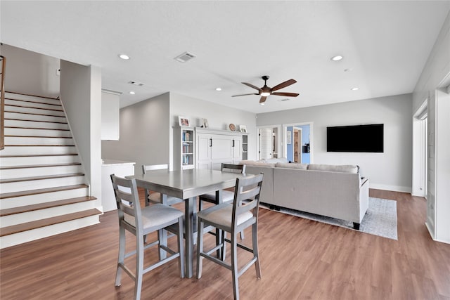 dining space with ceiling fan and hardwood / wood-style flooring