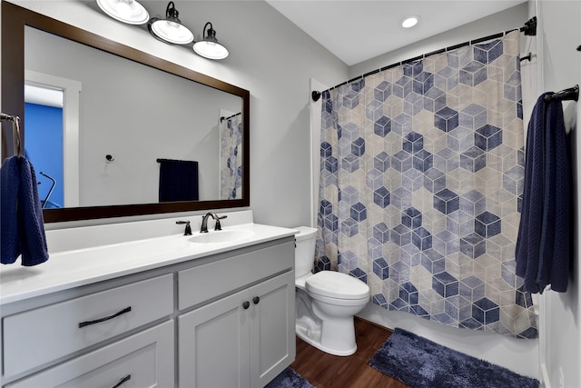 bathroom with wood-type flooring, vanity, and toilet