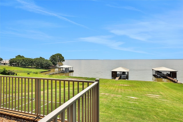 exterior space with a boat dock, a water view, and a lawn