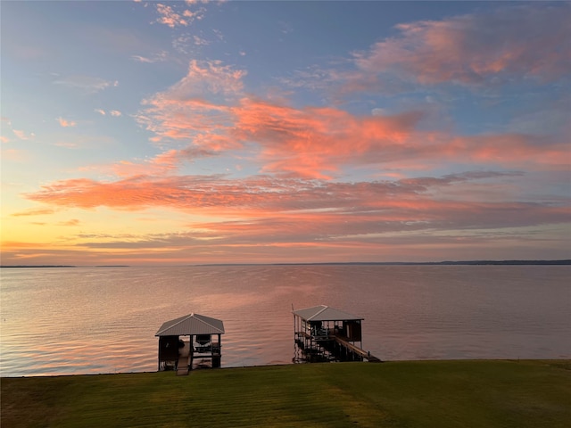 view of dock featuring a water view and a lawn