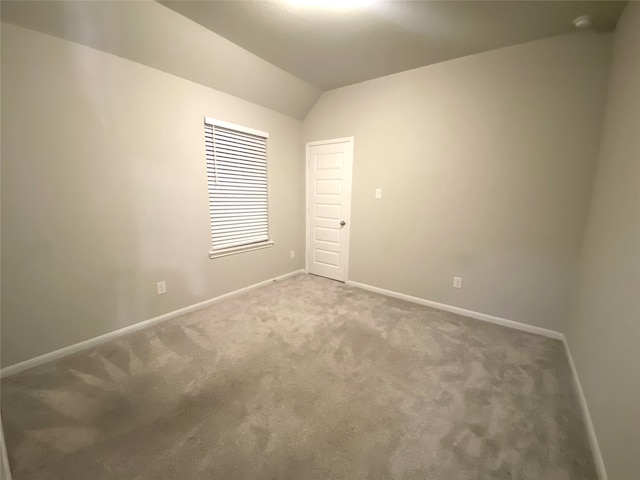 unfurnished room featuring carpet flooring and lofted ceiling