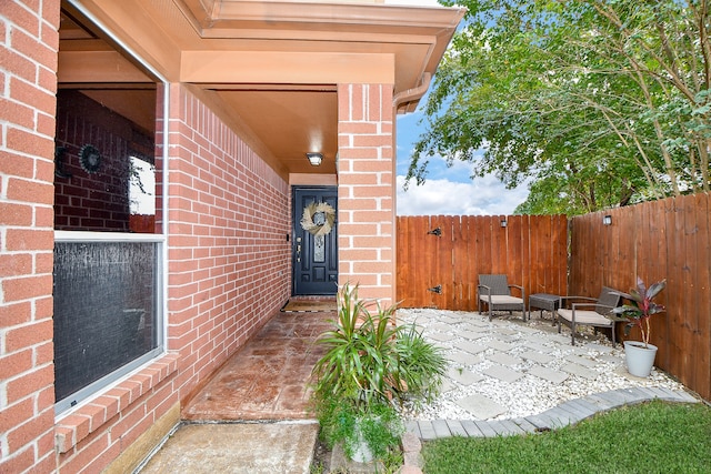 view of exterior entry with a patio