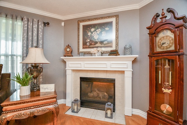 sitting room featuring a tile fireplace, light hardwood / wood-style flooring, and ornamental molding