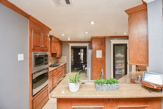 kitchen with backsplash, kitchen peninsula, stainless steel appliances, and ornamental molding