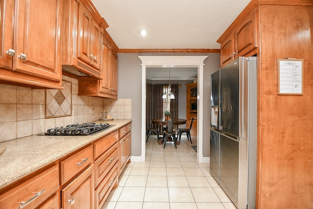 kitchen featuring stainless steel appliances, a notable chandelier, ornamental molding, and light tile patterned flooring