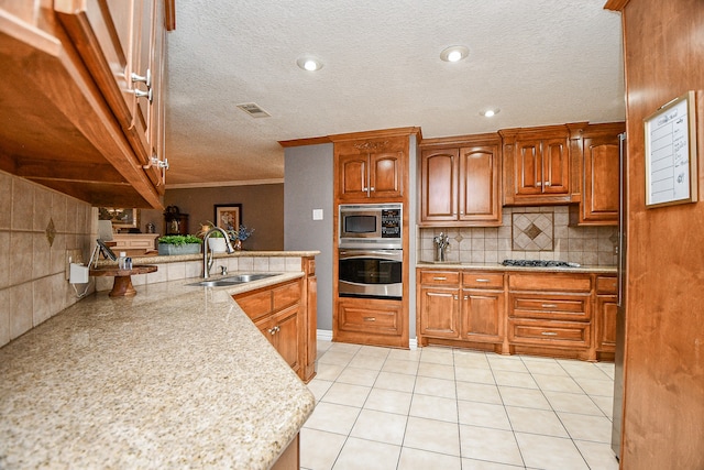 kitchen with sink, appliances with stainless steel finishes, decorative backsplash, light tile patterned flooring, and ornamental molding