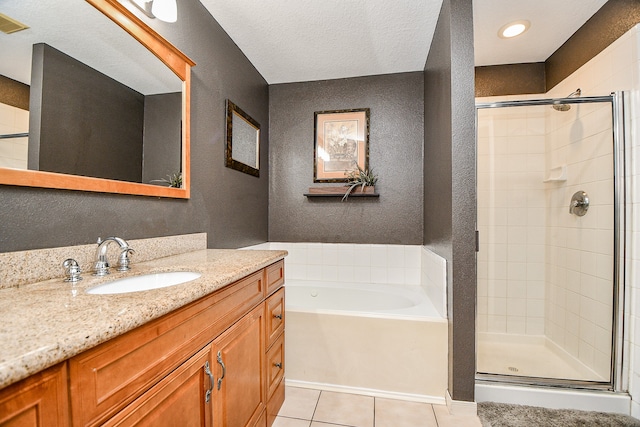 bathroom featuring tile patterned flooring, vanity, a textured ceiling, and plus walk in shower