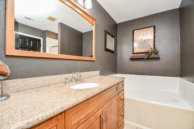 bathroom featuring a washtub and vanity