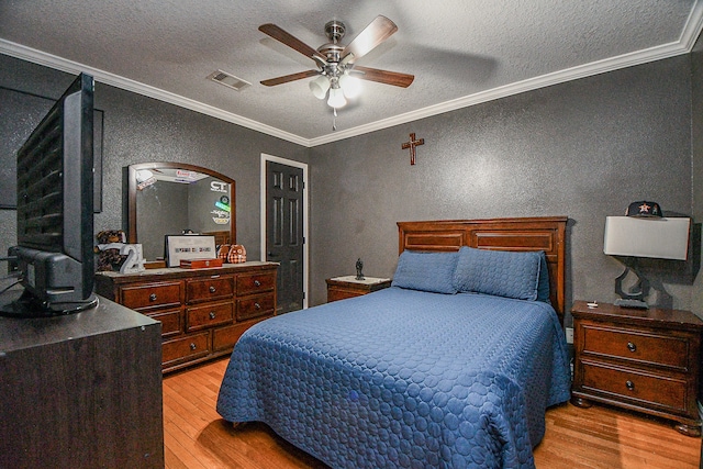 bedroom with a textured ceiling, light hardwood / wood-style flooring, ceiling fan, and crown molding