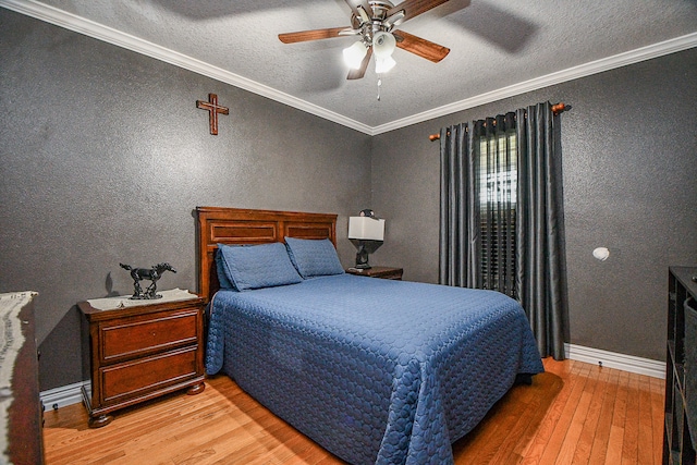 bedroom featuring hardwood / wood-style floors, a textured ceiling, ceiling fan, and crown molding