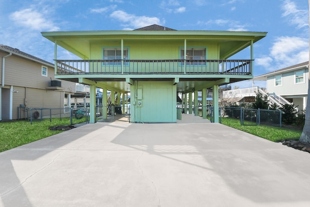 back of house featuring a balcony and a carport