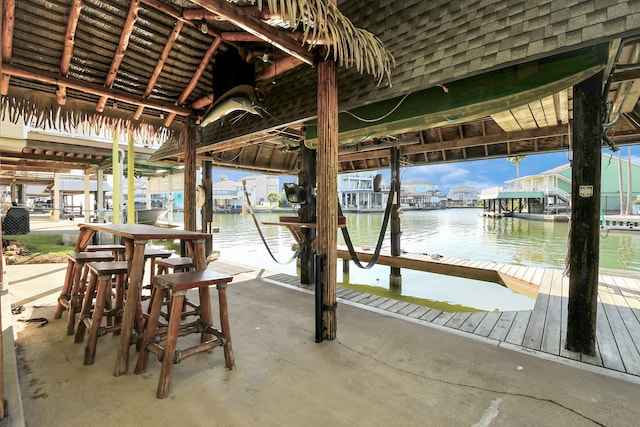 view of patio with a water view and a dock