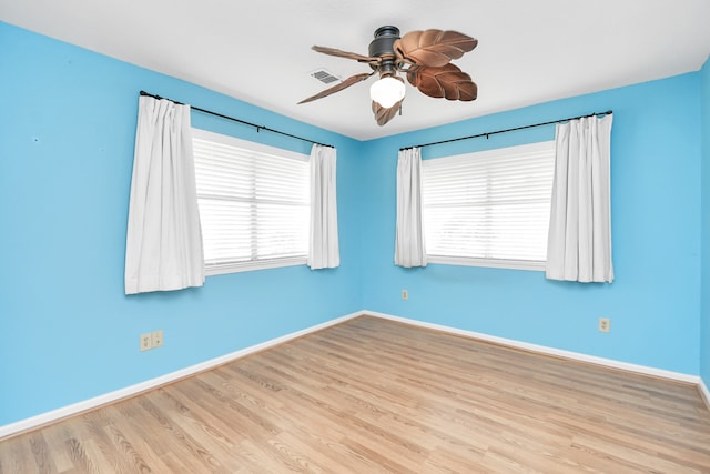 empty room with ceiling fan, a healthy amount of sunlight, and light hardwood / wood-style flooring