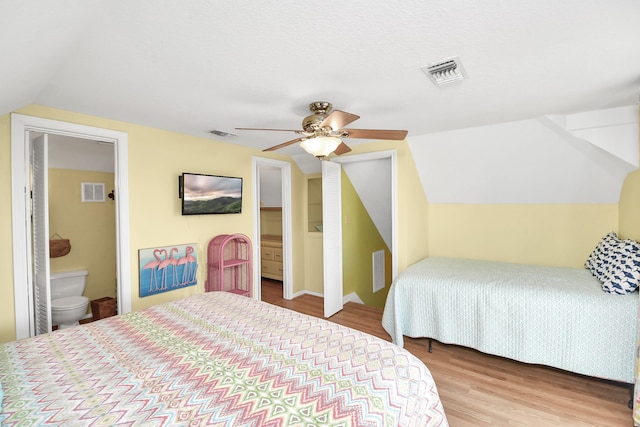 bedroom featuring ensuite bath, ceiling fan, light hardwood / wood-style floors, and lofted ceiling