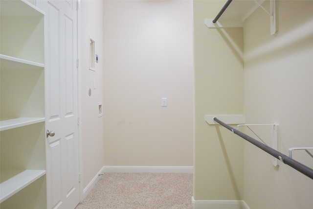 spacious closet featuring light colored carpet