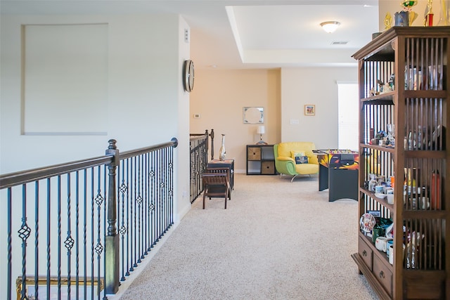 game room featuring light colored carpet and a tray ceiling