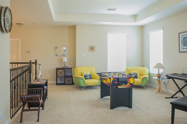 playroom with light colored carpet and a raised ceiling