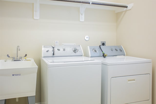 laundry area with washing machine and clothes dryer and sink