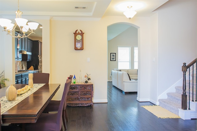 dining space with ornamental molding, dark wood-type flooring, and an inviting chandelier