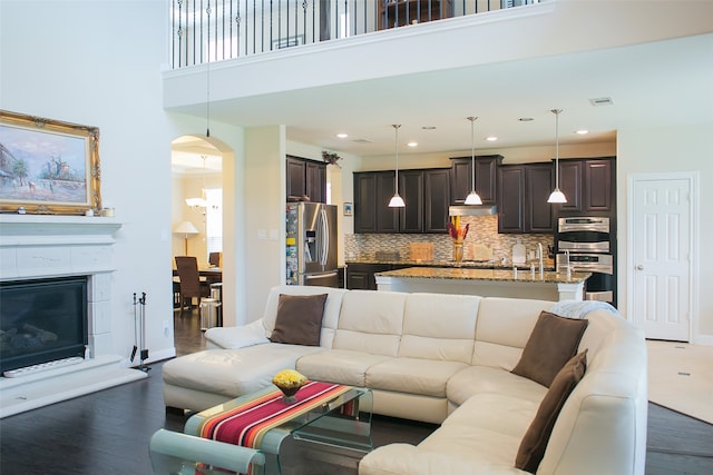 living room featuring a high ceiling and dark hardwood / wood-style flooring