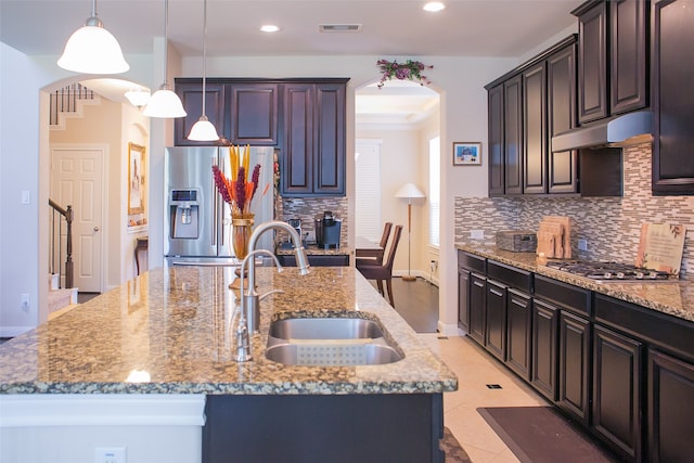 kitchen featuring a center island with sink, decorative light fixtures, sink, and stainless steel appliances