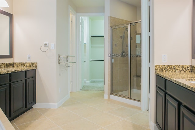 bathroom featuring tile patterned flooring, vanity, and a shower with shower door