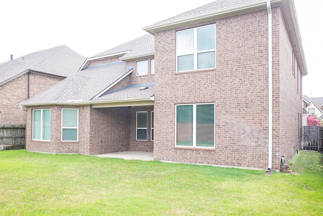 back of house with a yard and a patio