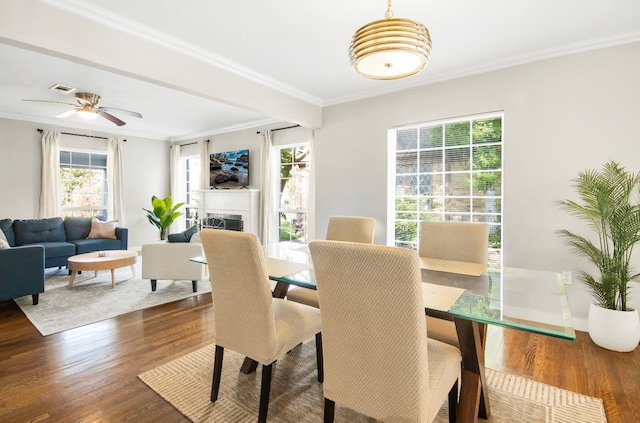 dining space with ceiling fan, dark hardwood / wood-style flooring, and ornamental molding