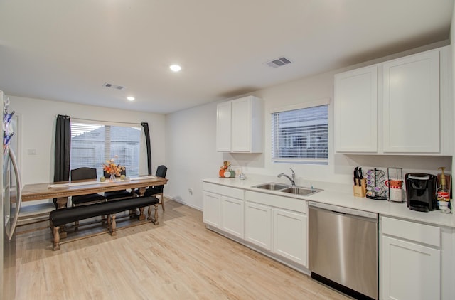 kitchen with white cabinetry, light hardwood / wood-style flooring, stainless steel dishwasher, and sink