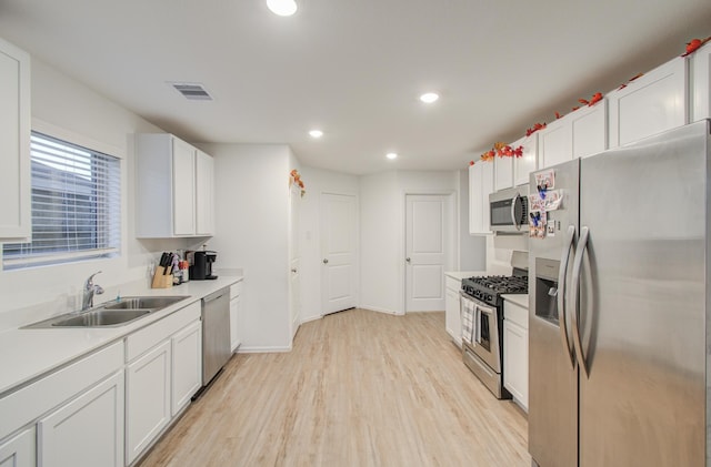 kitchen with white cabinetry, sink, light wood-type flooring, and appliances with stainless steel finishes