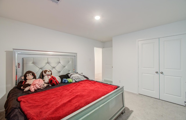 bedroom with light colored carpet and a closet