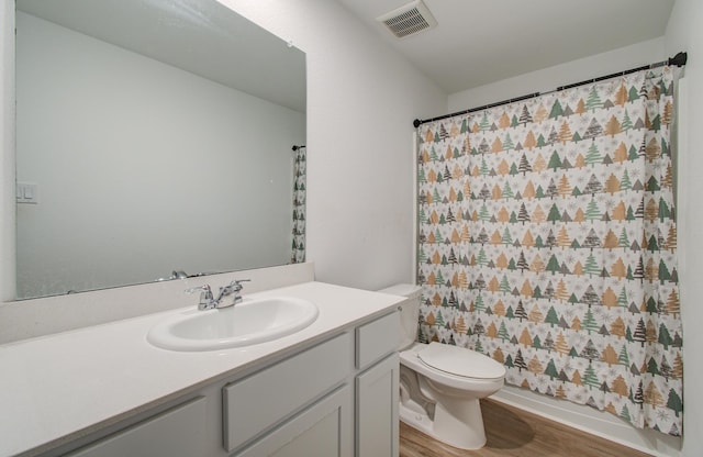 bathroom with vanity, hardwood / wood-style flooring, toilet, and walk in shower