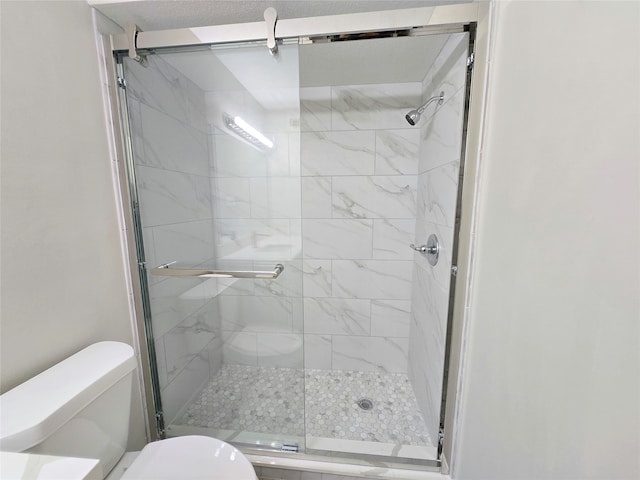 bathroom featuring an enclosed shower and toilet