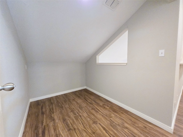 additional living space featuring hardwood / wood-style flooring and vaulted ceiling