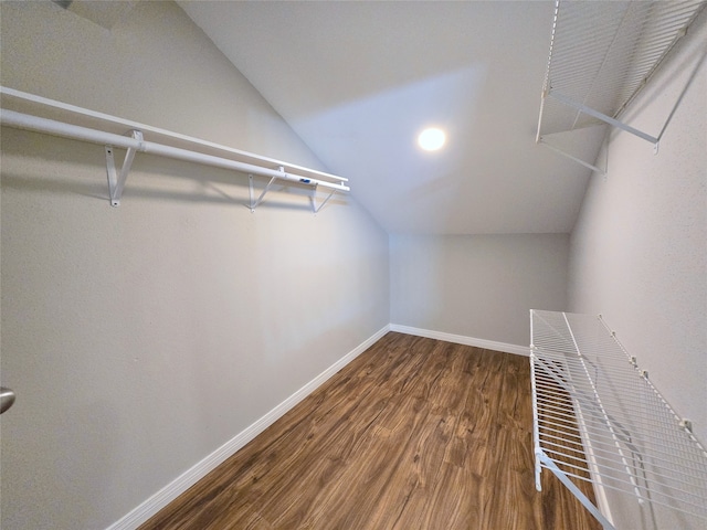 spacious closet with dark hardwood / wood-style floors and lofted ceiling