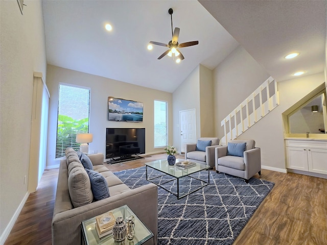 living room with ceiling fan, high vaulted ceiling, and dark wood-type flooring