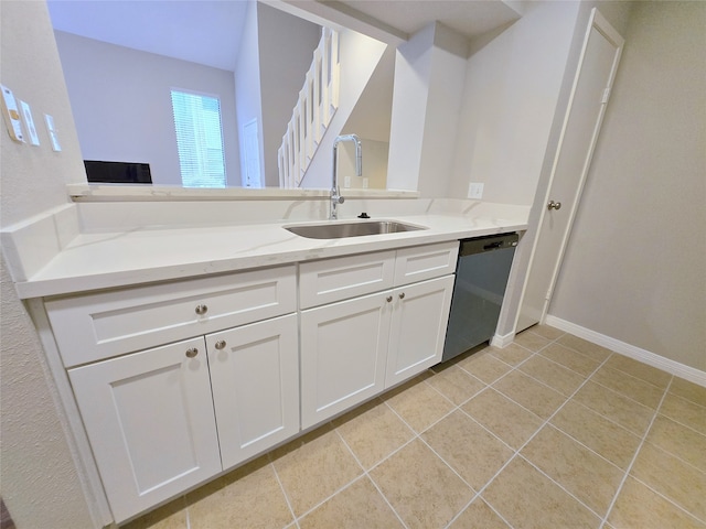 kitchen featuring dishwasher, white cabinets, sink, light stone countertops, and light tile patterned floors